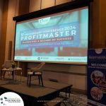 A conference stage set for the 10th Anniversary Conference 2024 of ProfitMaster, featuring a large screen and two chairs. The event is scheduled for September 11-13, 2024, in Clark, Pampanga.