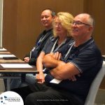 Three individuals sit at a table with notebooks and pens, attentively listening. A logo in the lower left corner reads "PROFITMASTER Global Outsourcing.