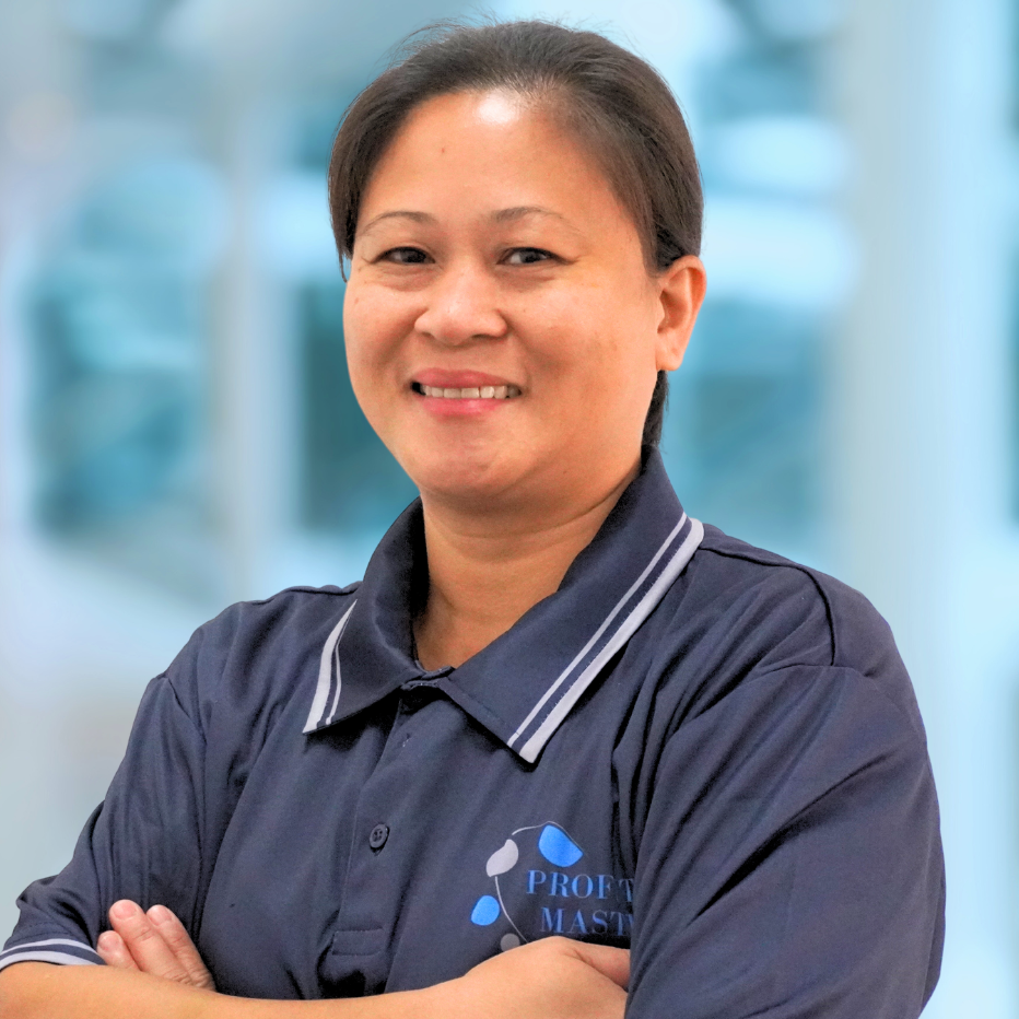 A person wearing a dark blue shirt with the "Property Master" logo, arms crossed, smiling at the camera against a blurry background, exuding team spirit.